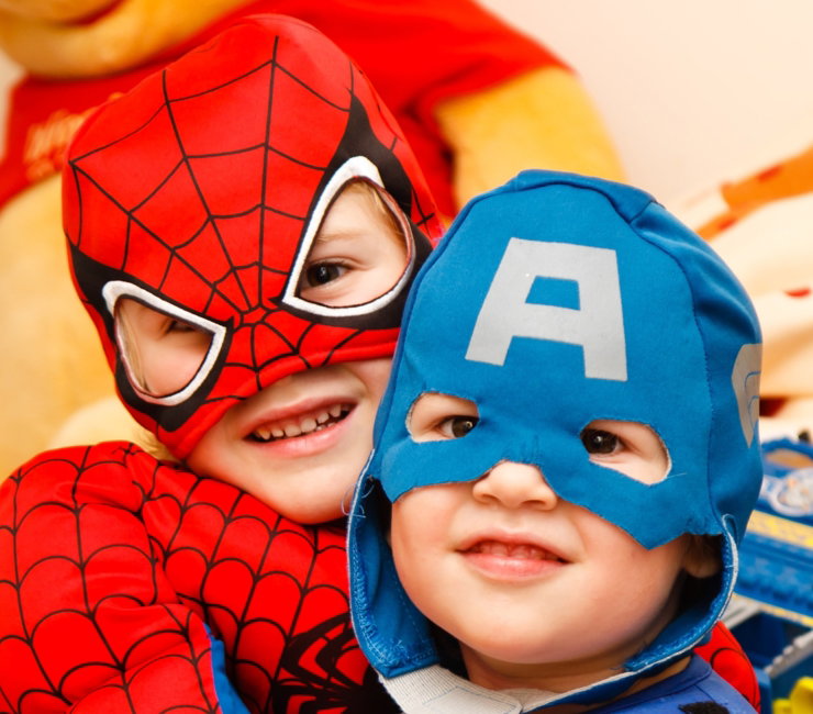 two toddlers wearing superhero masks